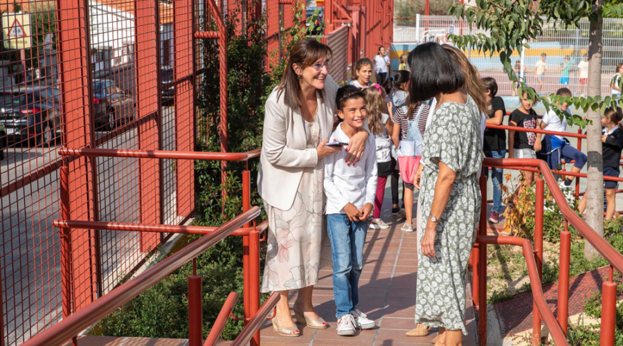 La alcaldesa junto a un niño en la puerta de un colegio